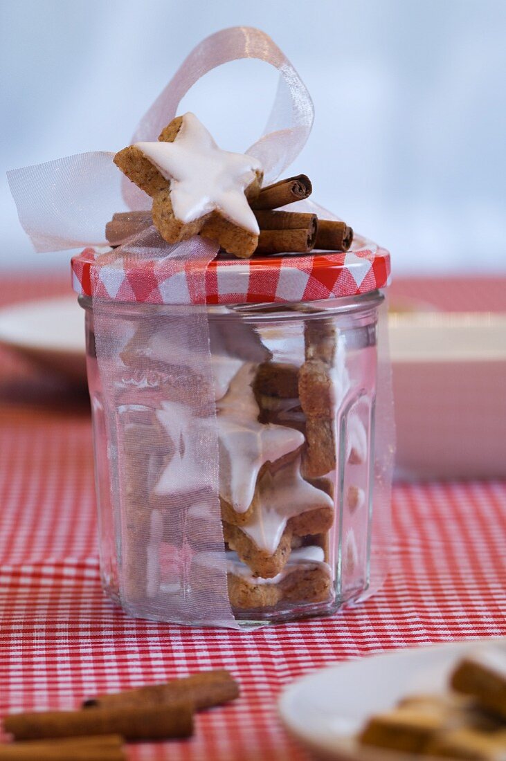Star-shaped cinnamon biscuits in a preserving jar