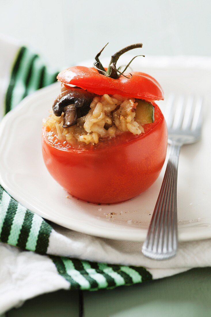 A tomato stuffed with mushroom risotto