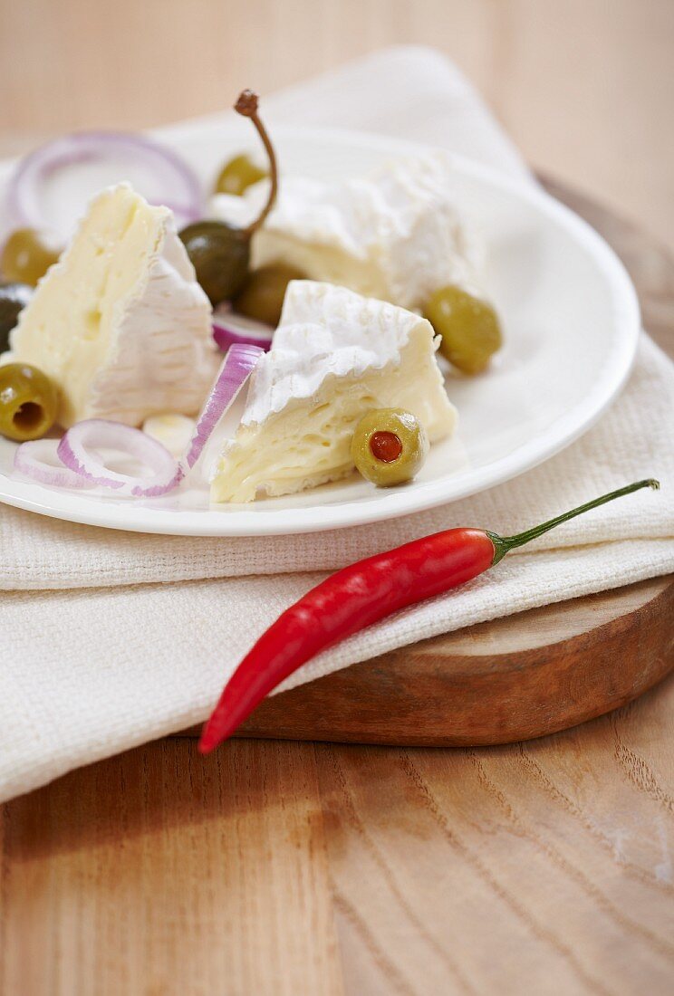 Camembert with olives, capers, onions and a chilli pepper