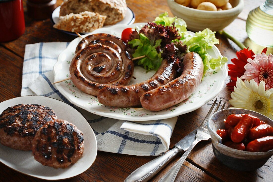 A plate of barbecued sausage spirals and sausages