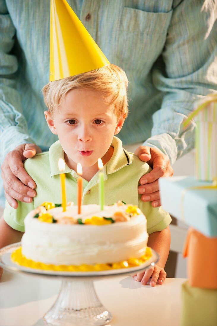 Young child blowing out birthday candles