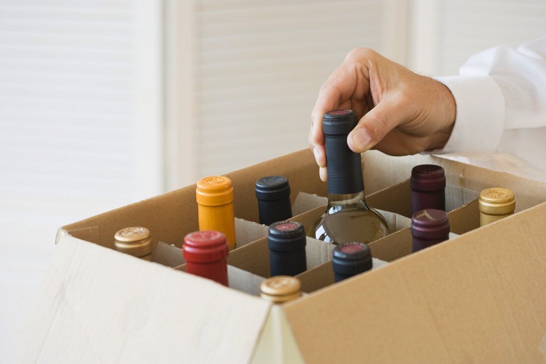 Man taking wine bottle out of case