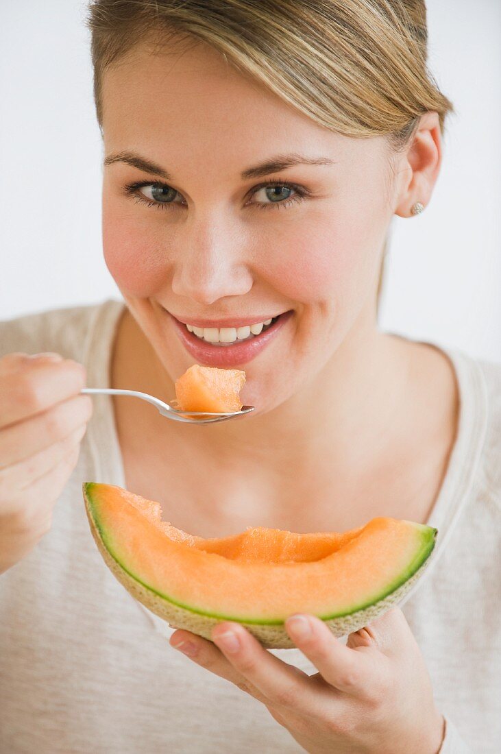 Woman eating melon wedge
