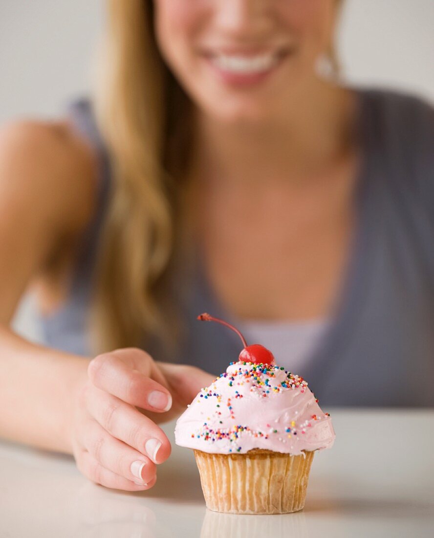 Woman reaching for cupcake