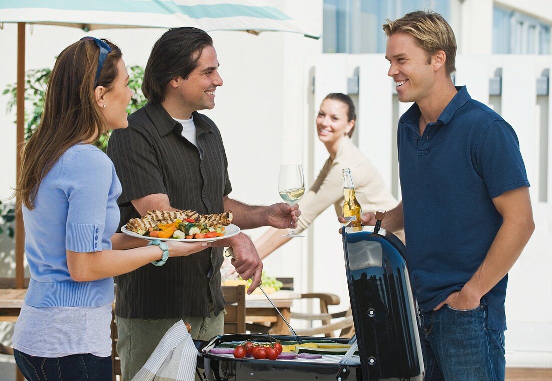 Couples barbecuing on patio