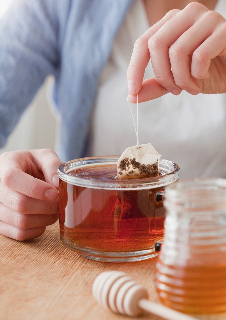 Eine Tasse Tee mit Teebeutel und Honig