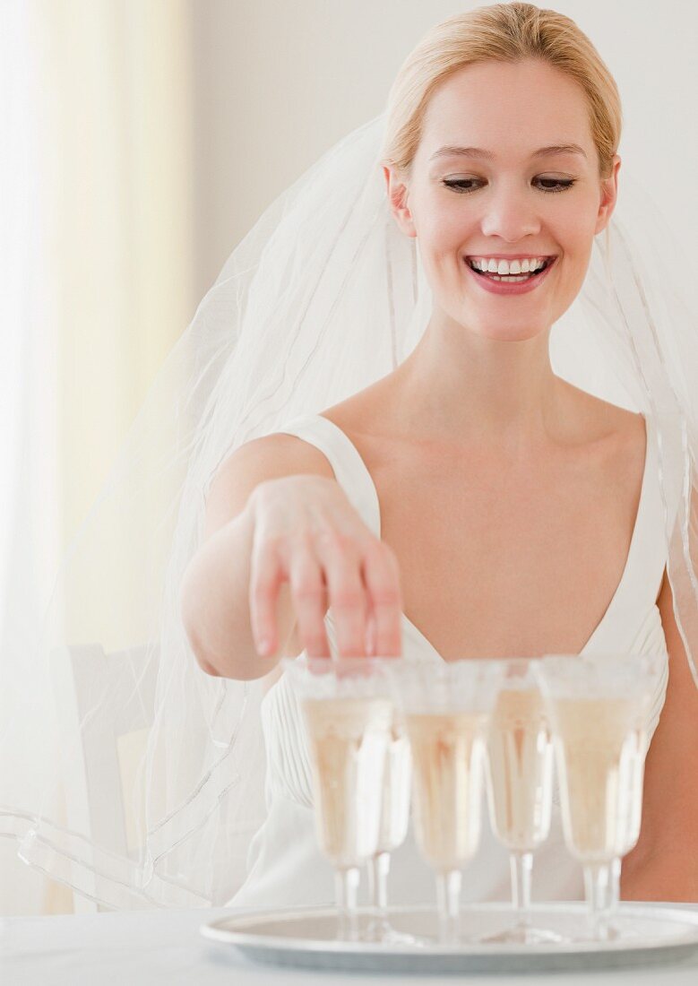 Braut greift nach einem Glas Champagner