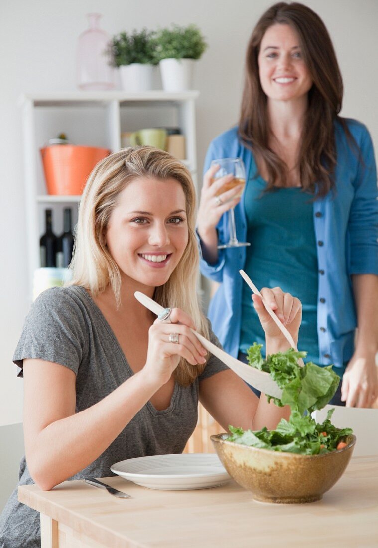 Junge Frau nimmt sich Salat