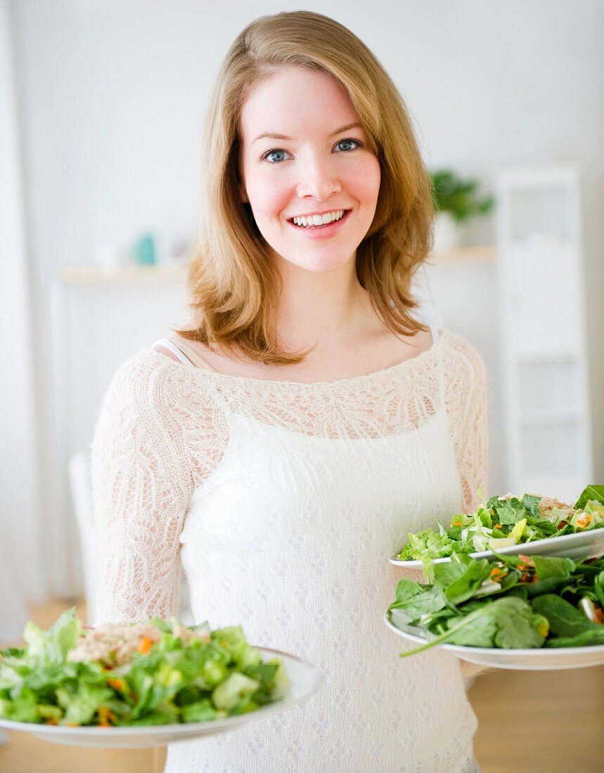 Frau serviert Salat