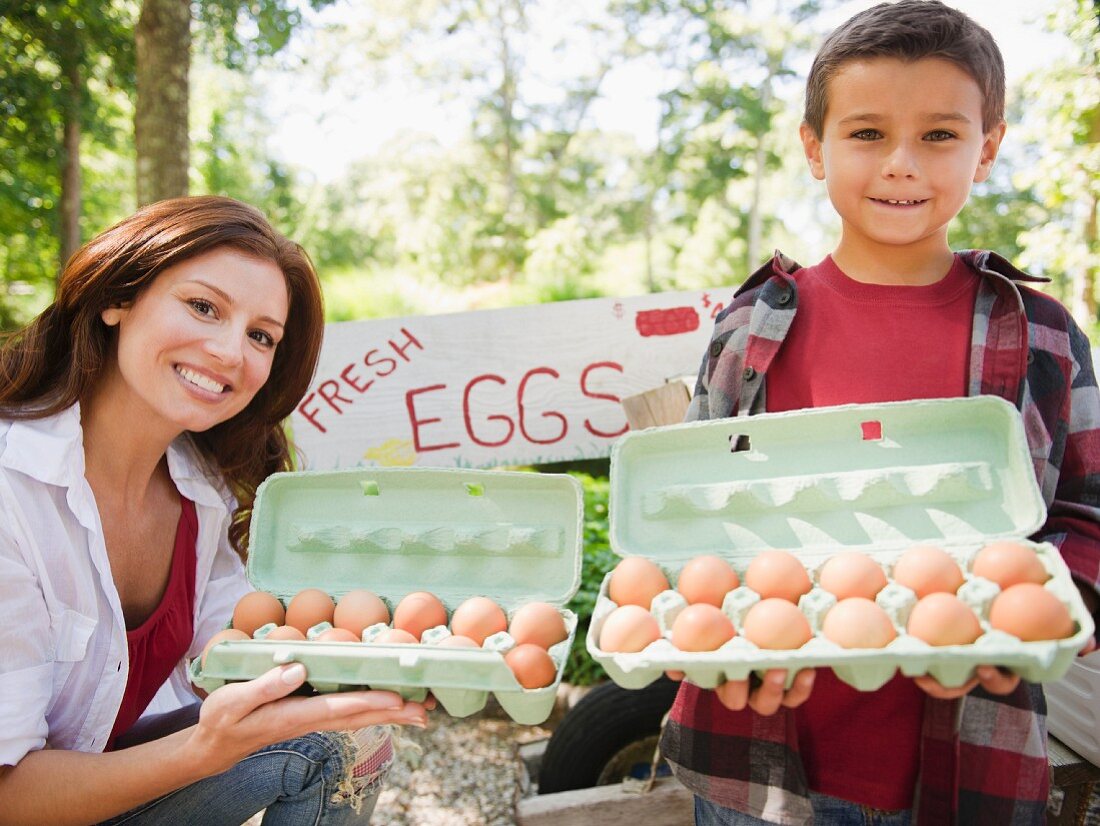 USA, New York, Flanders, Mother and son (8-9) selling fresh eggs