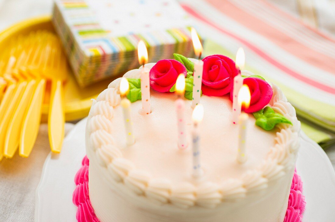 Geburtstagskuchen mit Zuckerrosen und Kerzen