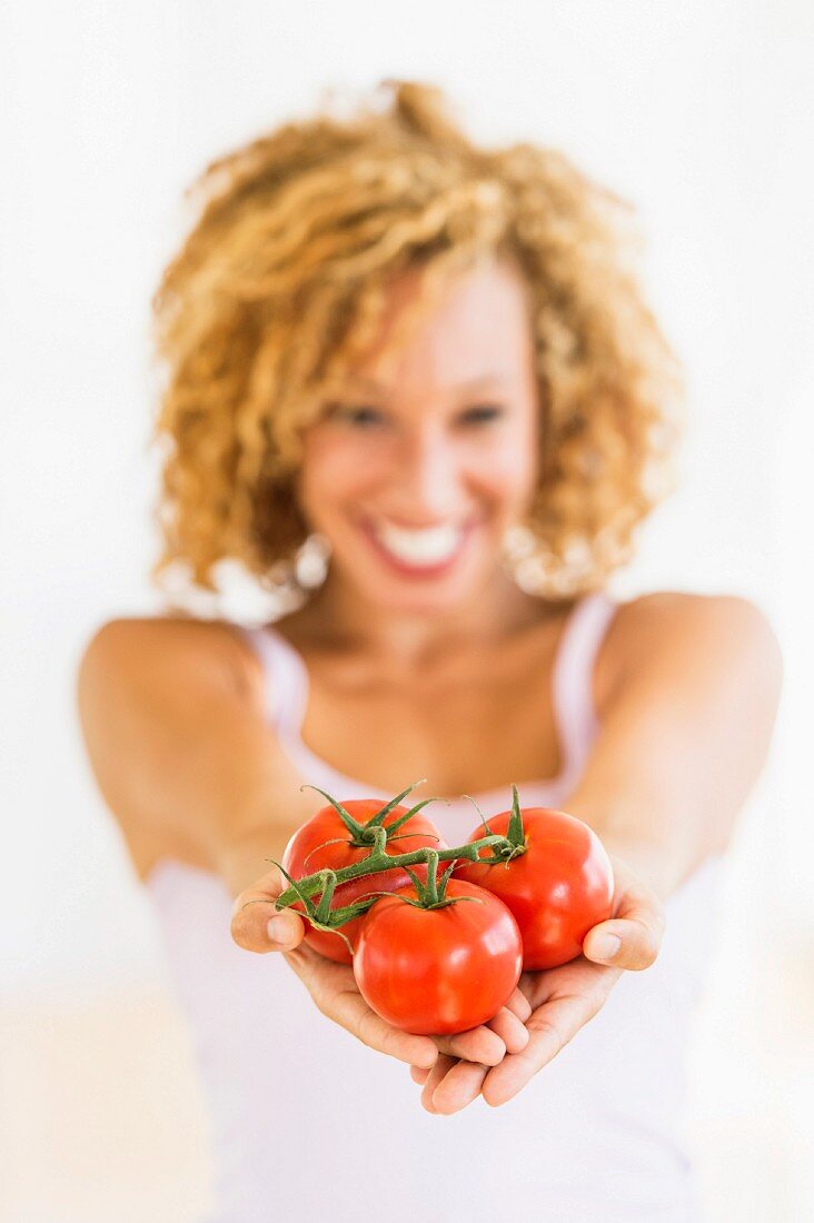Junge Frau hält Tomaten auf den Händen