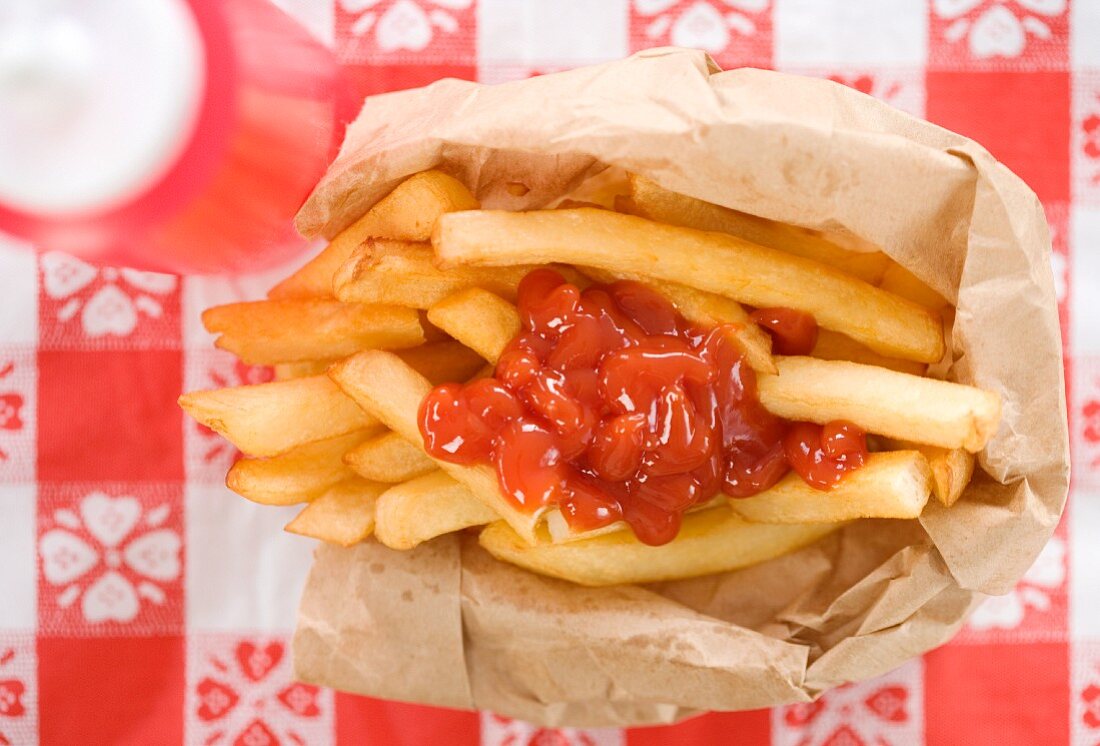 Pommes frites mit Ketchup in einer Papiertüte