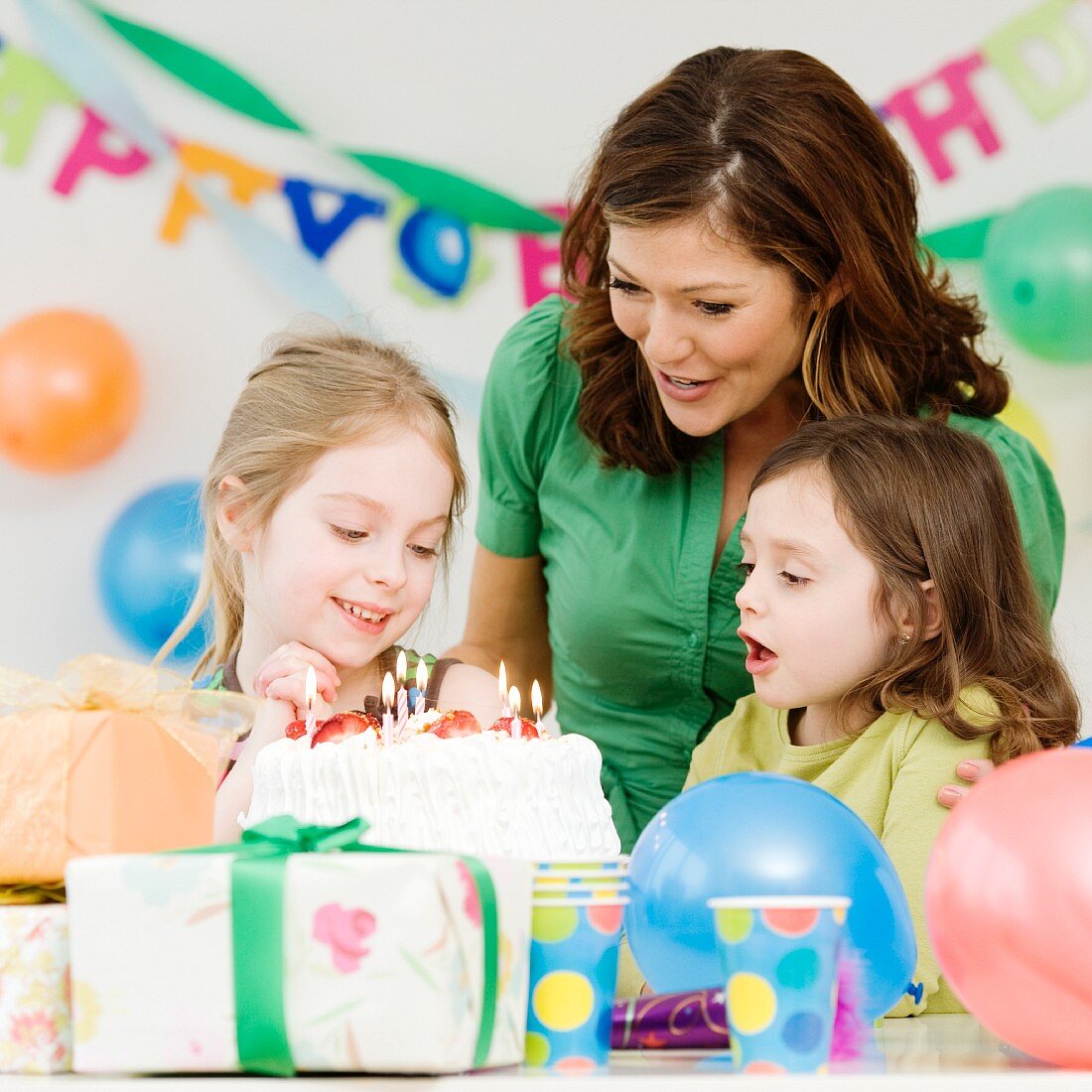 Girl celebrating birthday with mother and sister