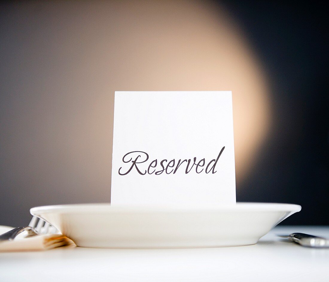 Reserved sign on place setting, studio shot
