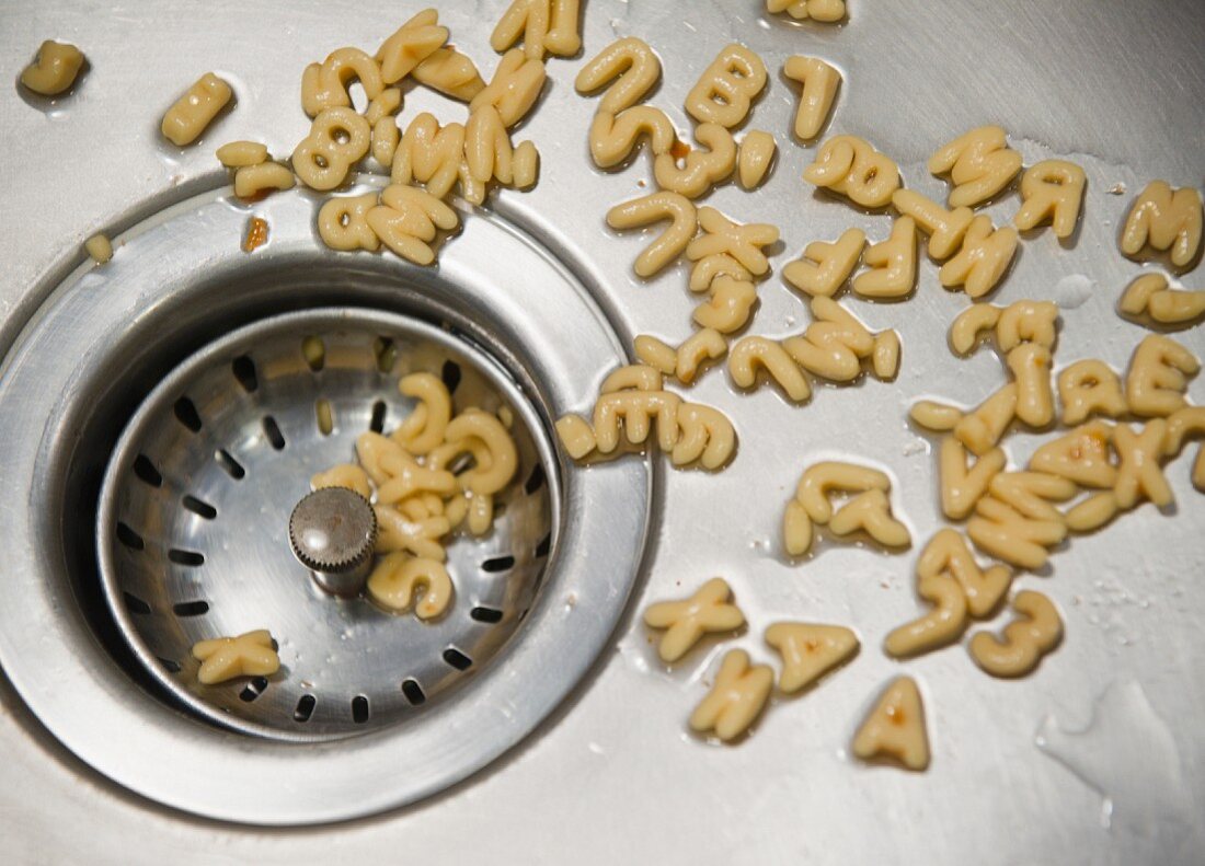 Close up of letter noodles in kitchen sink