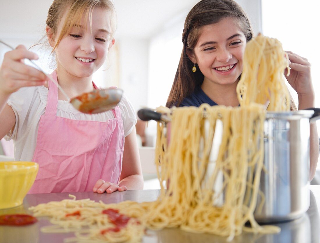 Two girls cooking pasta