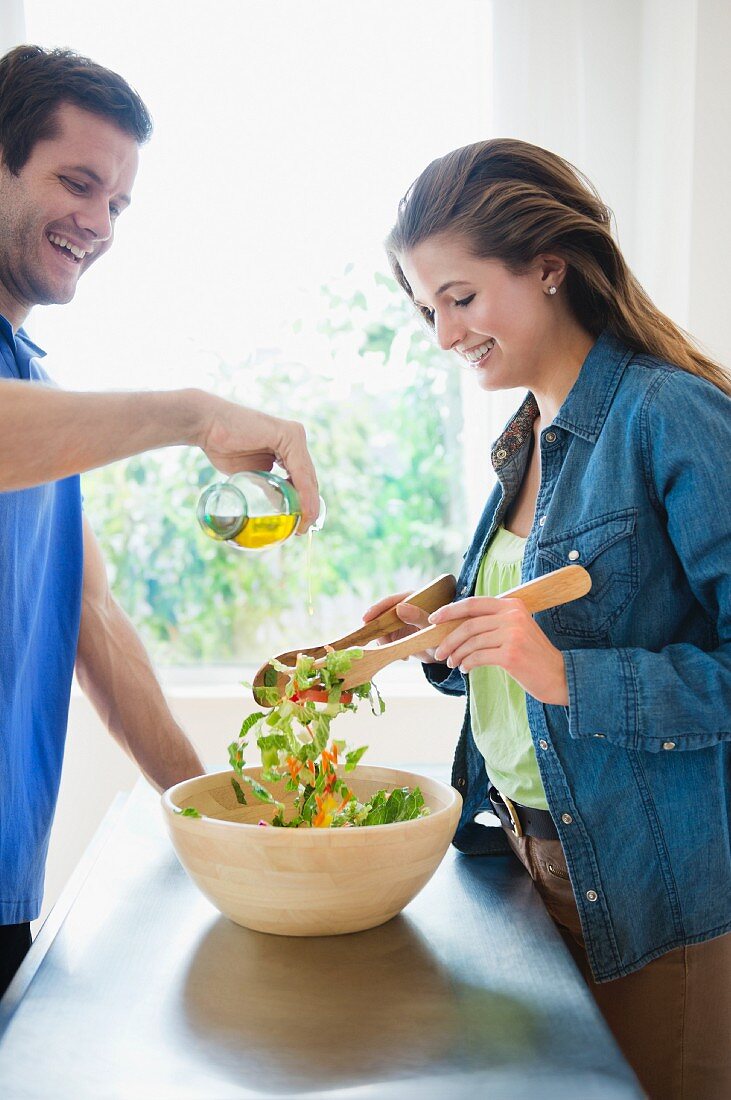 Junges Paar bereitet zusammen Salat zu
