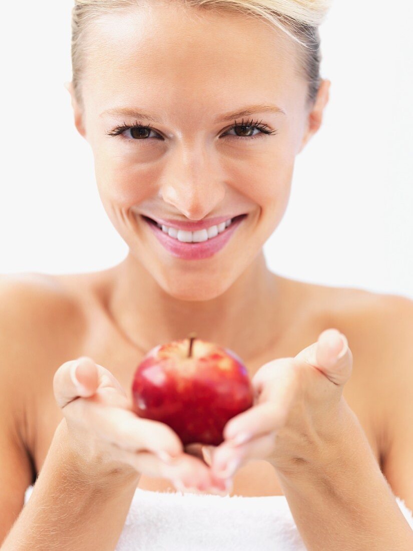 Lachende Frau mit rotem Apfel