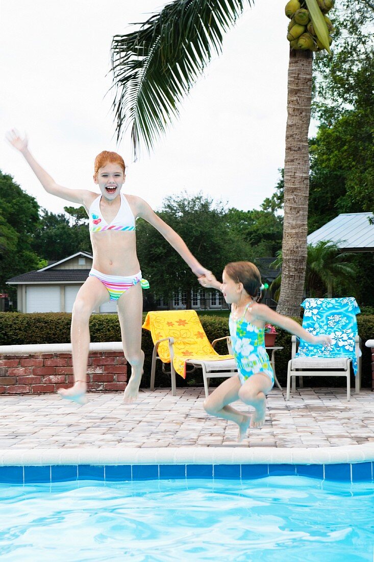 Girls jumping into swimming pool