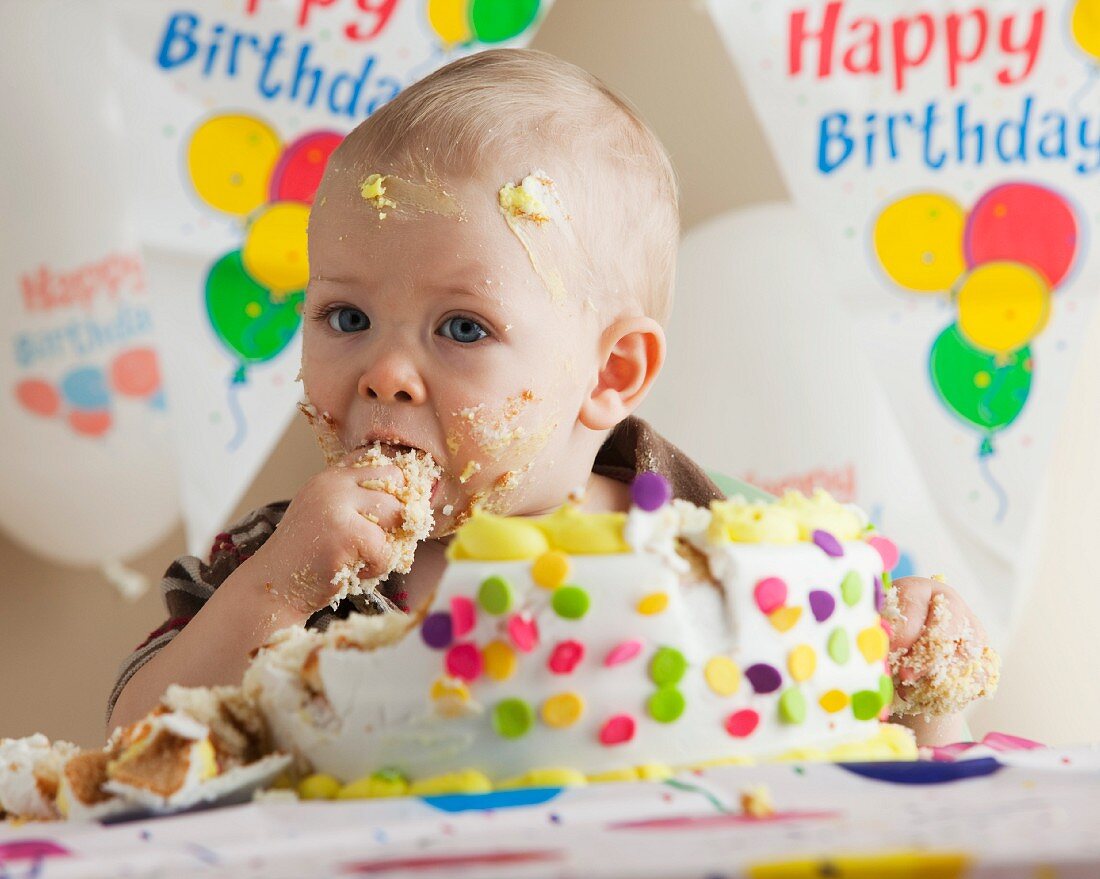 Kleiner Junge isst genussvoll seine Geburtstagstorte