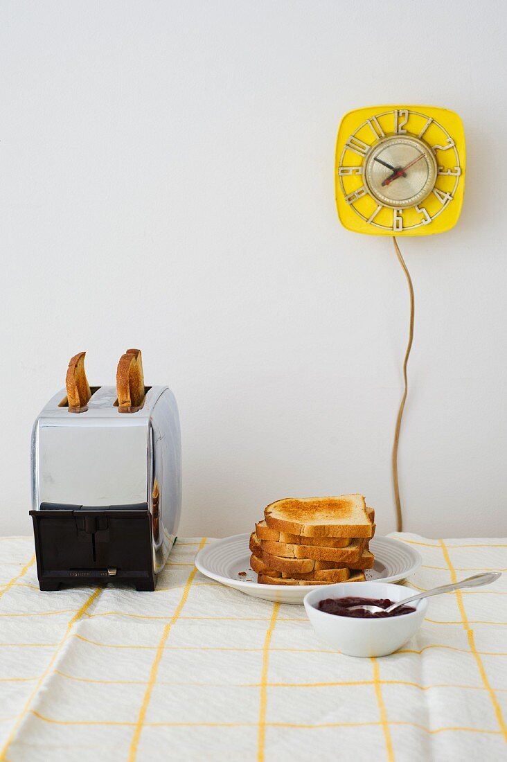 Frühstückstoast im Toaster und gestapelt; daneben ein Schälchen Marmelade