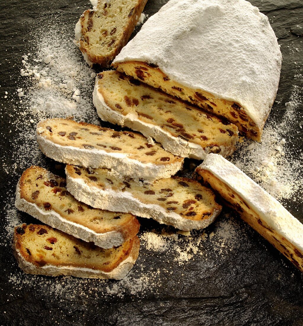 Christmas stollen dusted with icing sugar, partly sliced