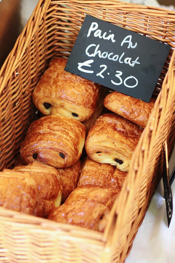 Chocolate croissants in a basket with a price tag