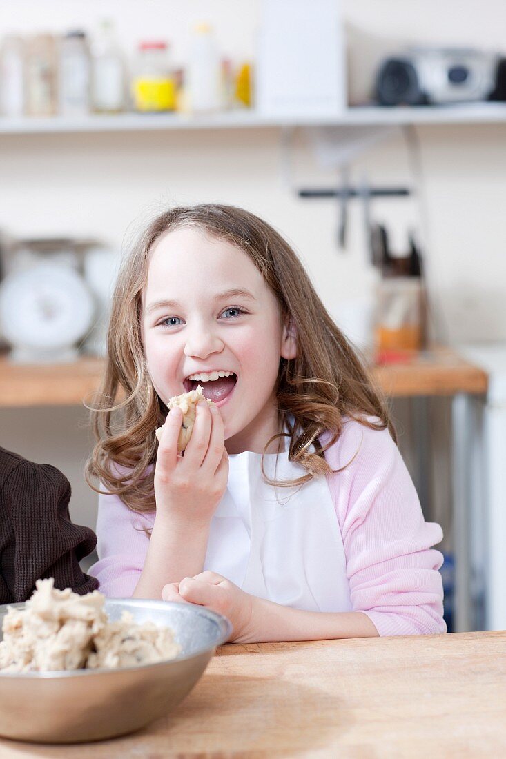 Young girl eating cookie batter