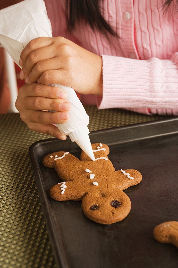 Mädchen verziert Lebkuchen mit Zuckerguss