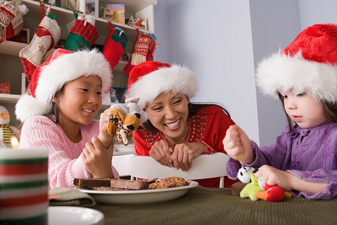 Mother with two daughters playing at Christmas morning