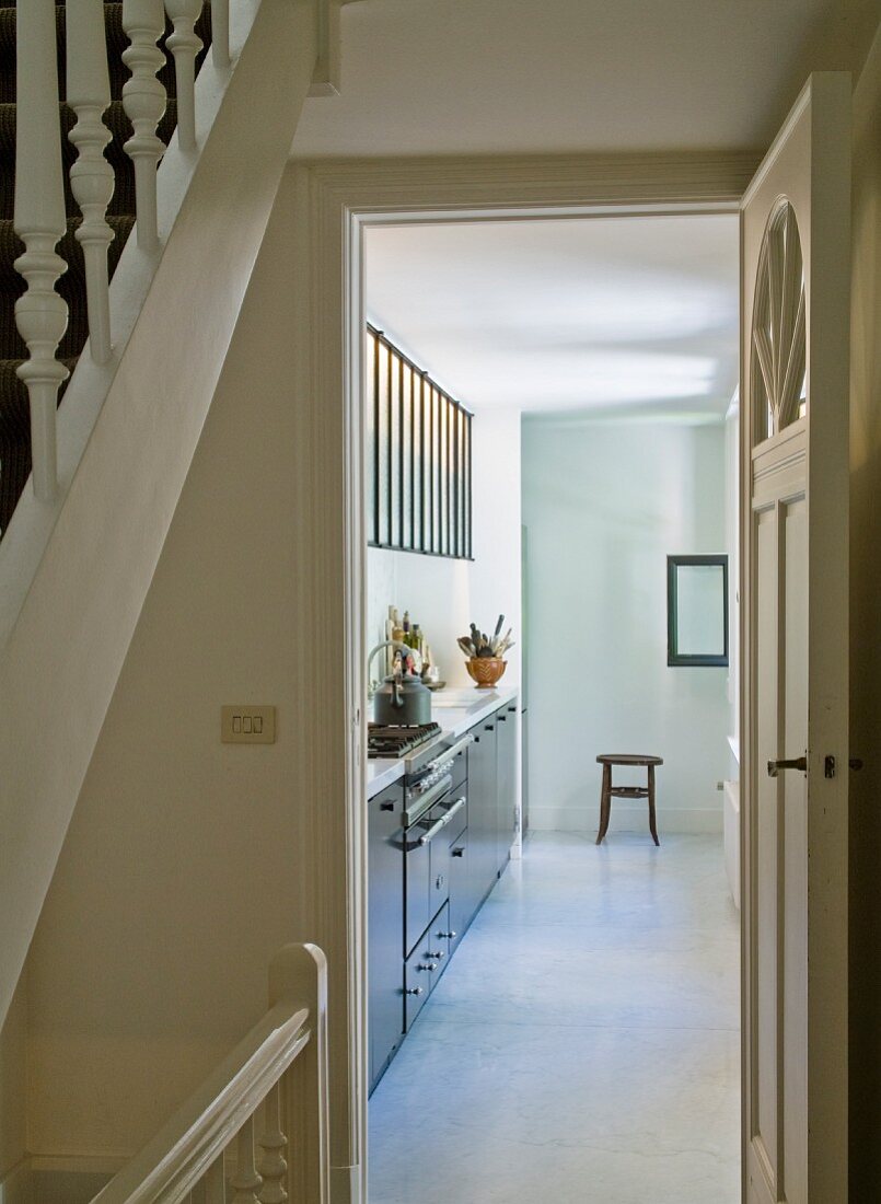 View from stairwell of modern kitchen counter through open kitchen door