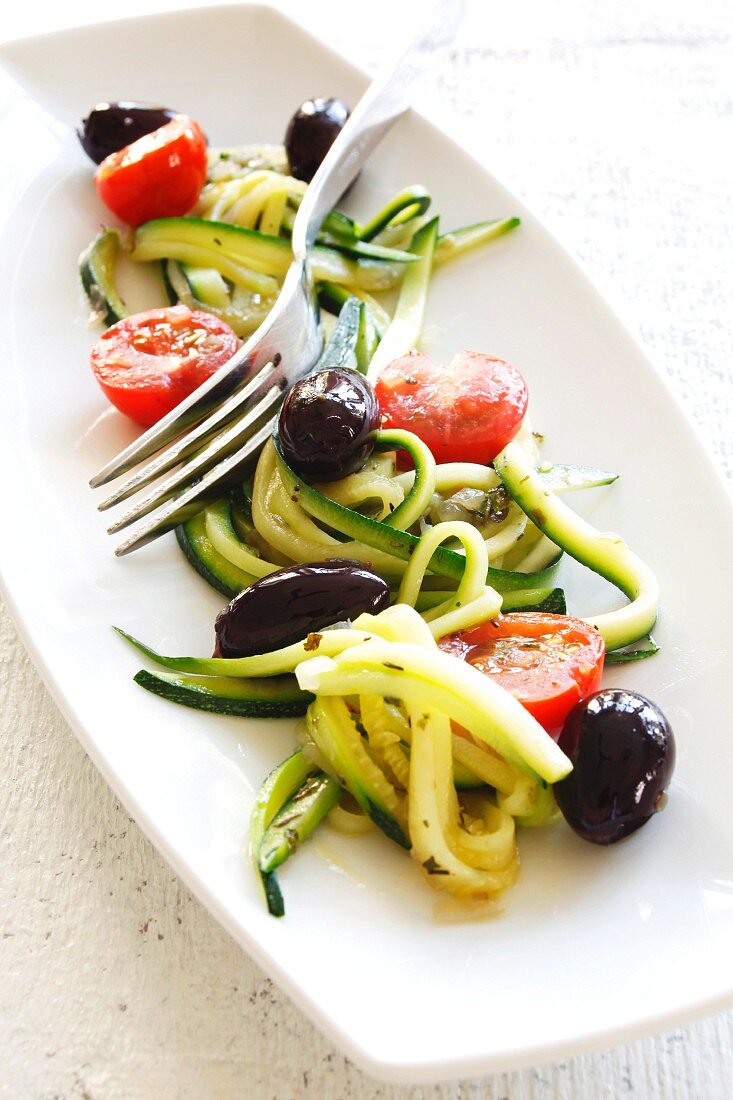 Steamed zucchini strips with tomatoes and olives