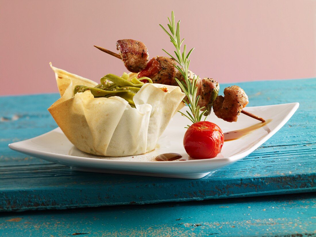 Meat kebabs with green tagliatelle in a phyllo basket