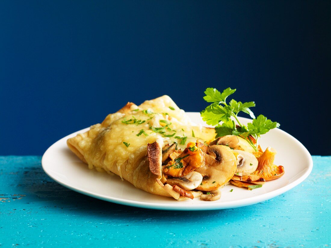 Crepes stuffed with mushrooms and gratinated with cheese