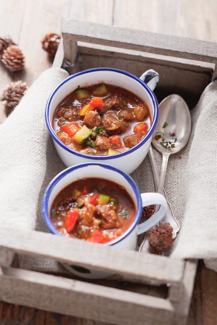 Two cups of goulash soup in a crate