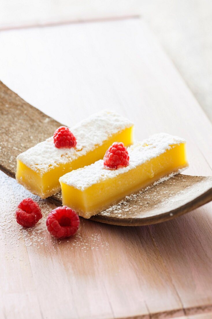 Lemon bars with powdered sugar and raspberries