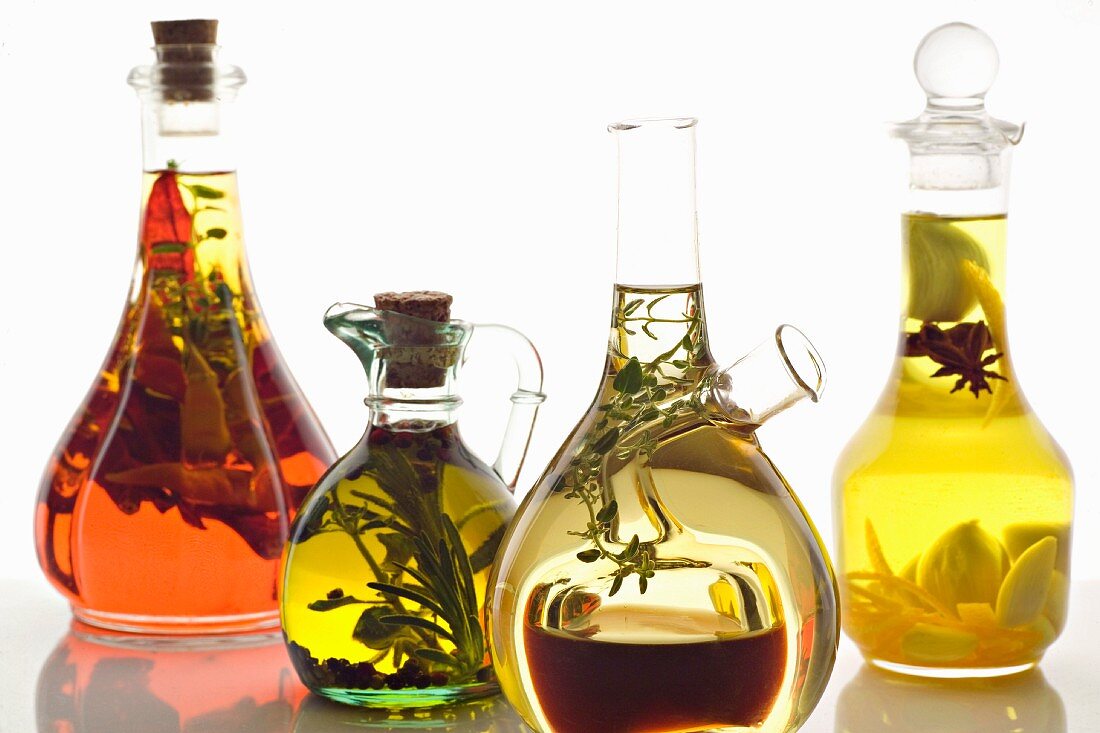 Verschiedene Olivenöle mit Kräutern und Gewürzen