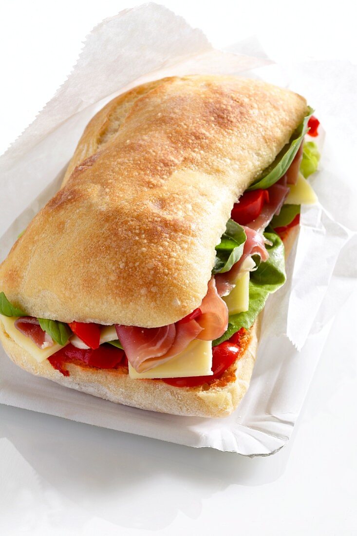 A sandwich filled with dry-cured ham, salad and cheese
