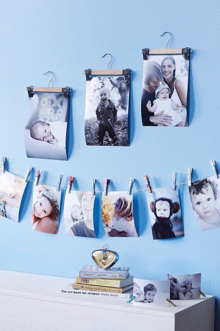 Family photos fixed on cord with mini clothes pegs and hung from small clothes hangers