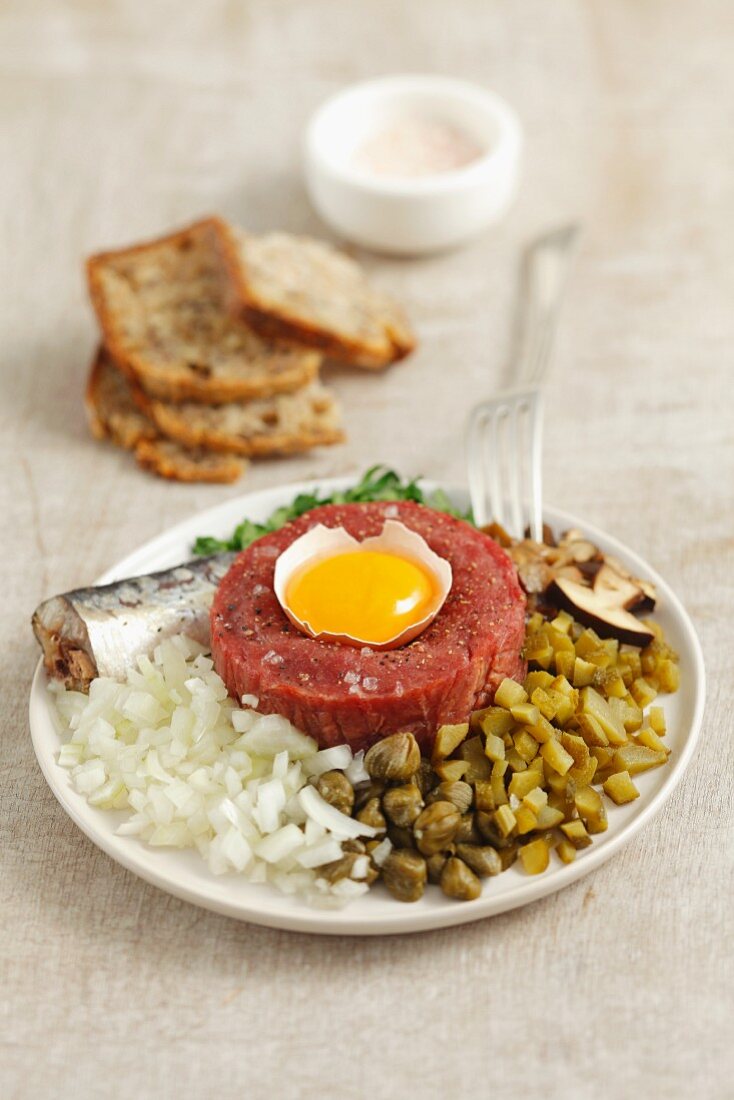 Classic beef tartar with egg, onion, pickled cucumber and mushrooms