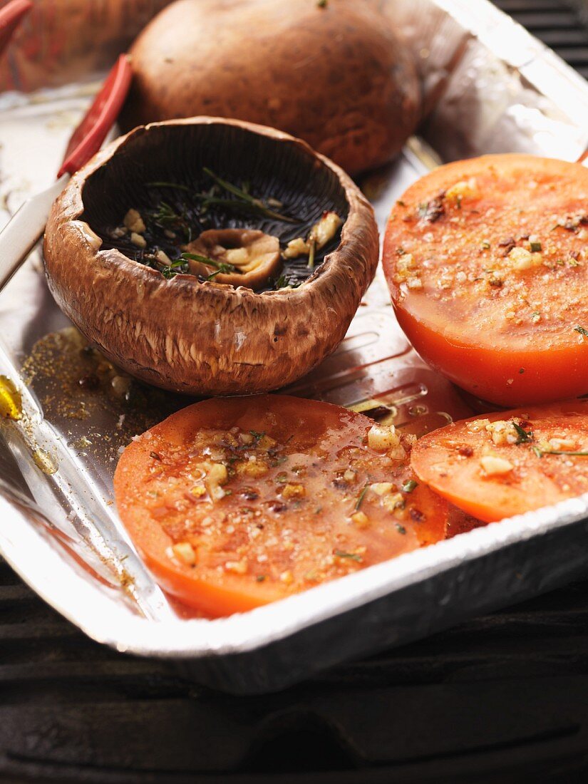 Gegrillte Portobellos und Tomaten in einer Aluschale