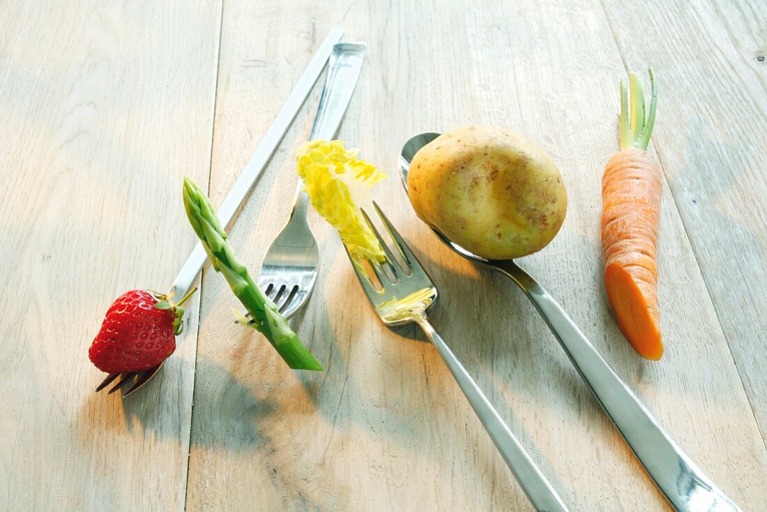 Fresh fruit and vegetables on forks and spoons