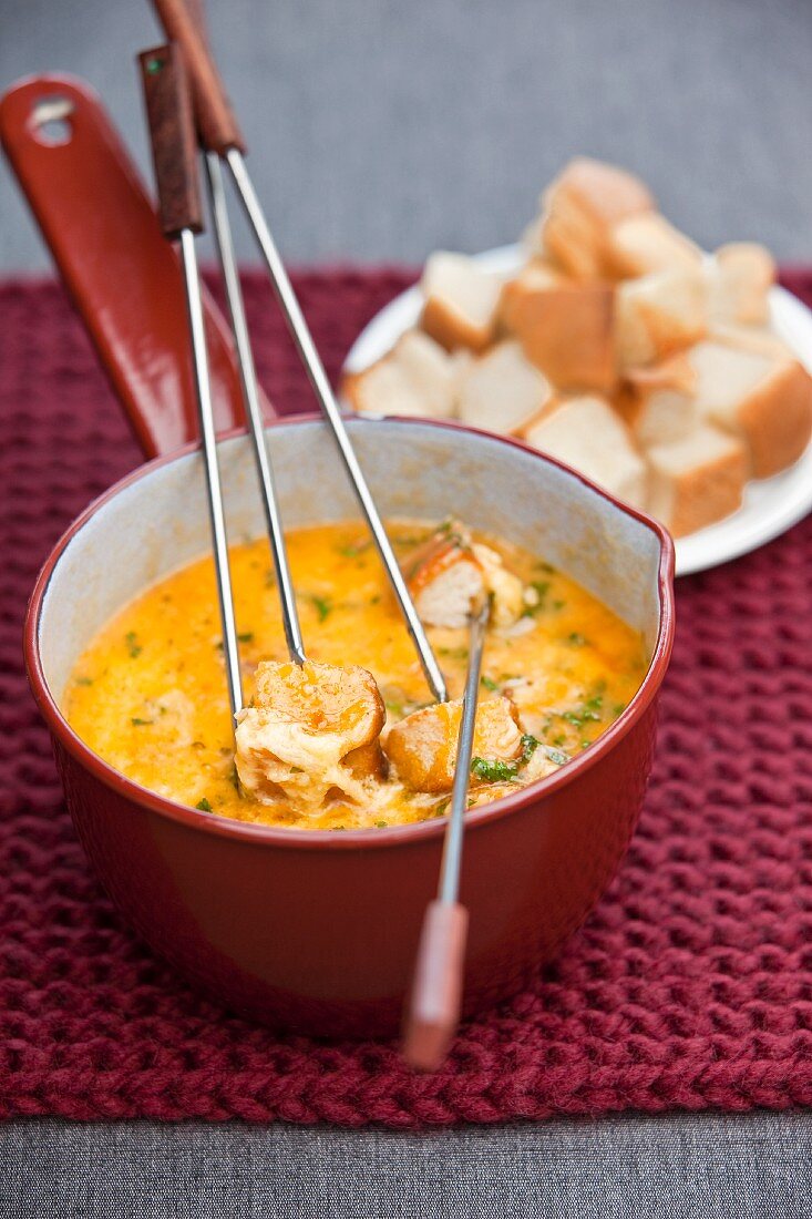 Cheese fondue with herbs and bread cubes