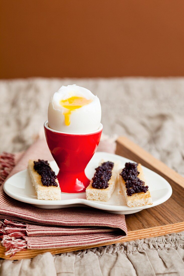 Soft boiled egg with caviar on 'soldiers' (thin toast slices)