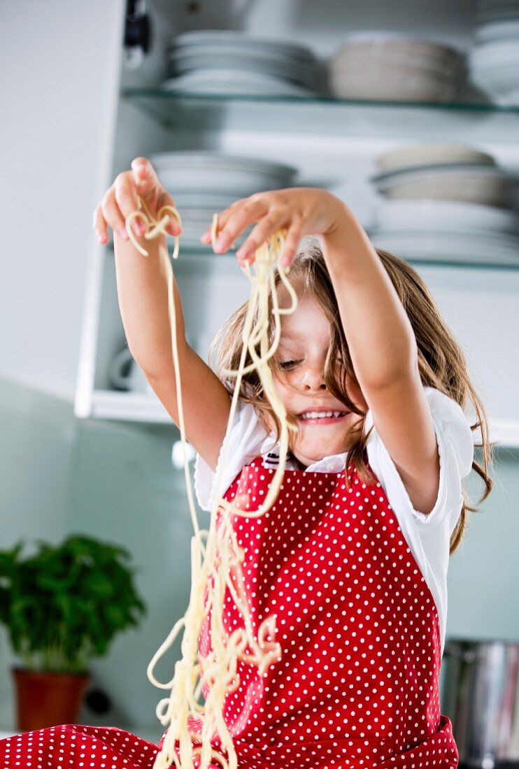 Mädchen spielt mit Spaghetti