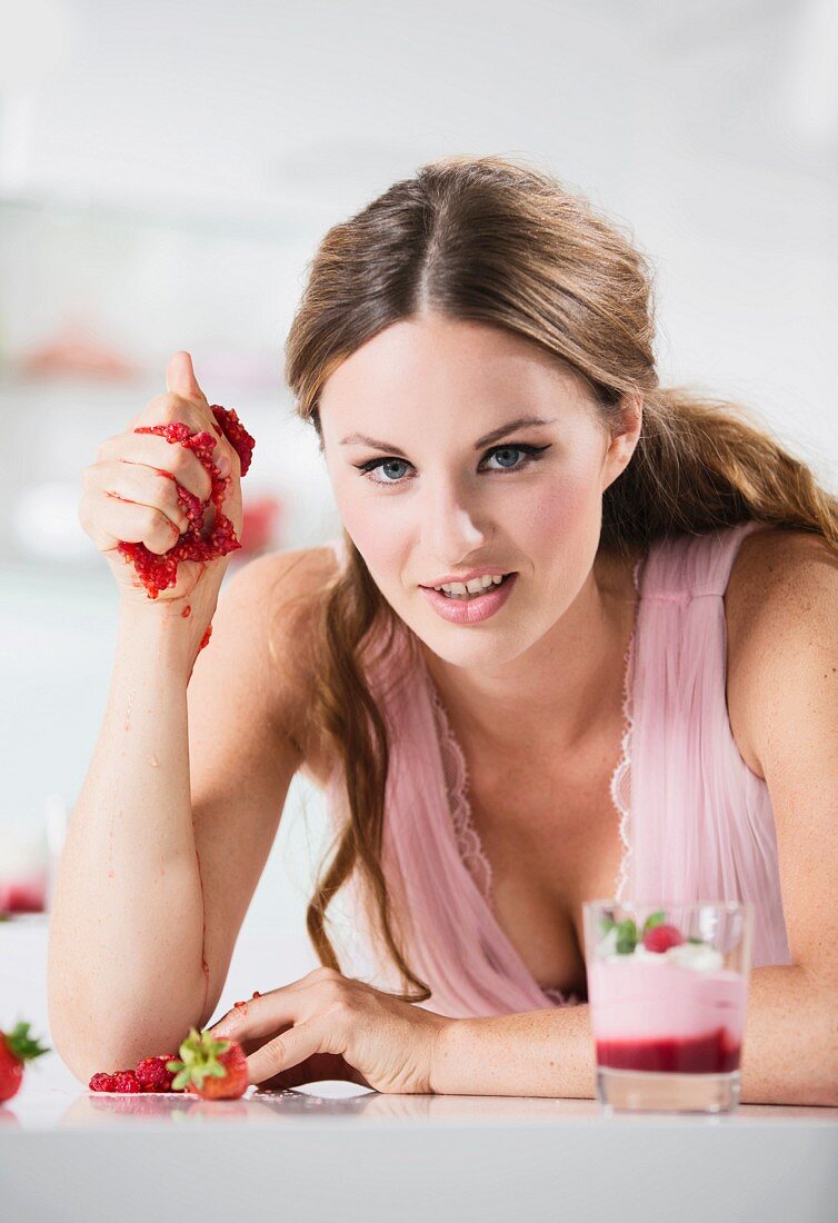 Junge Frau zerquetscht Johannisbeeren in der Hand