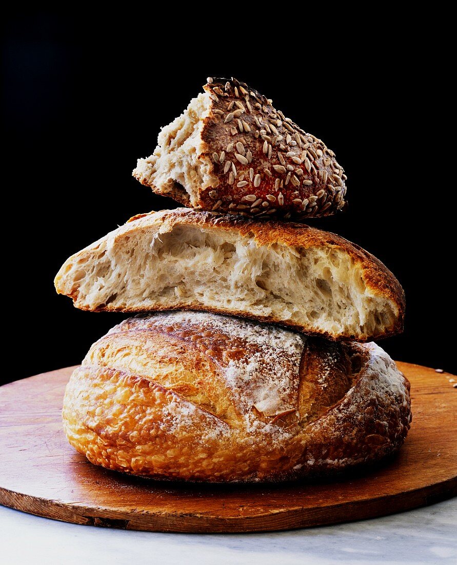 An assortment of sour dough breads, stacked