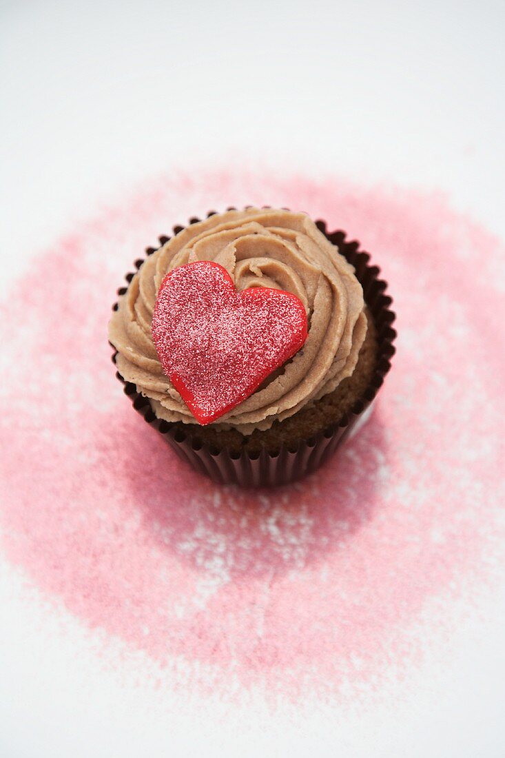 Rotes Herz auf Schokoladen-Cupcake