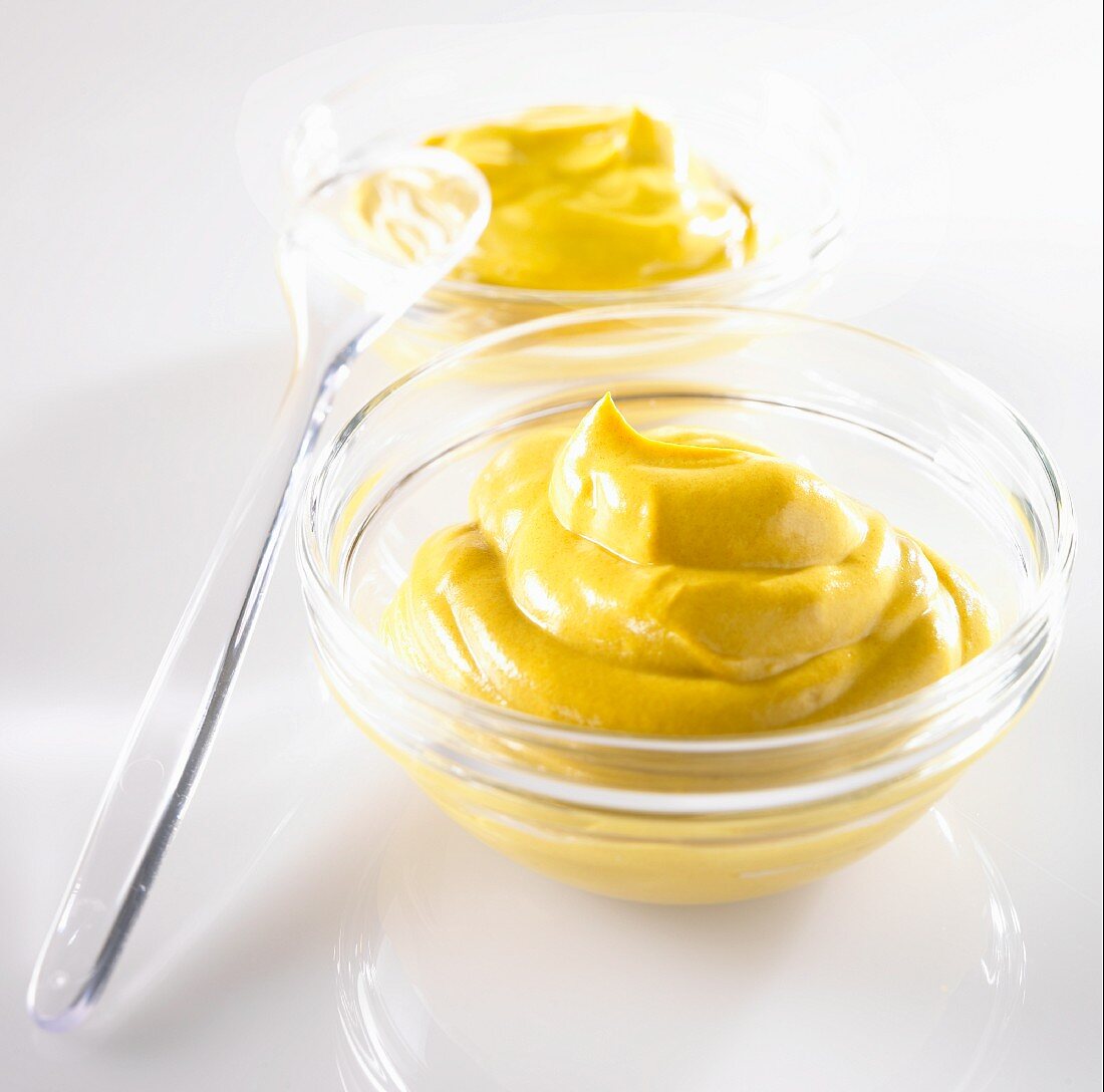 Mustard in a glass dish with a spoon